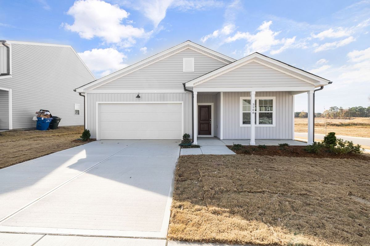A single-story suburban house with a two-car garage, driveway and landscaped front yard